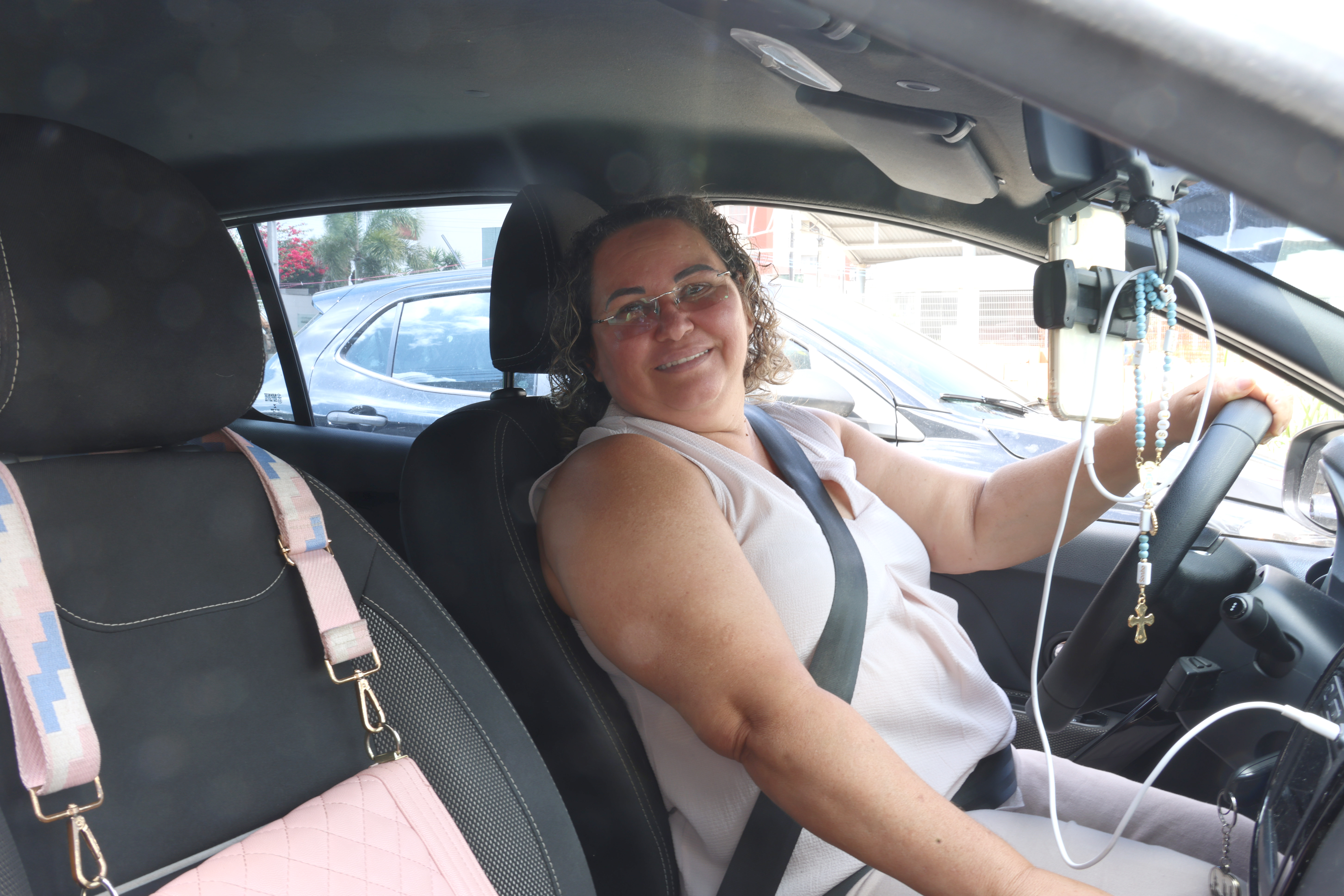 Silvane Gonçalves posa para a foto no banco de motorista do seu carro